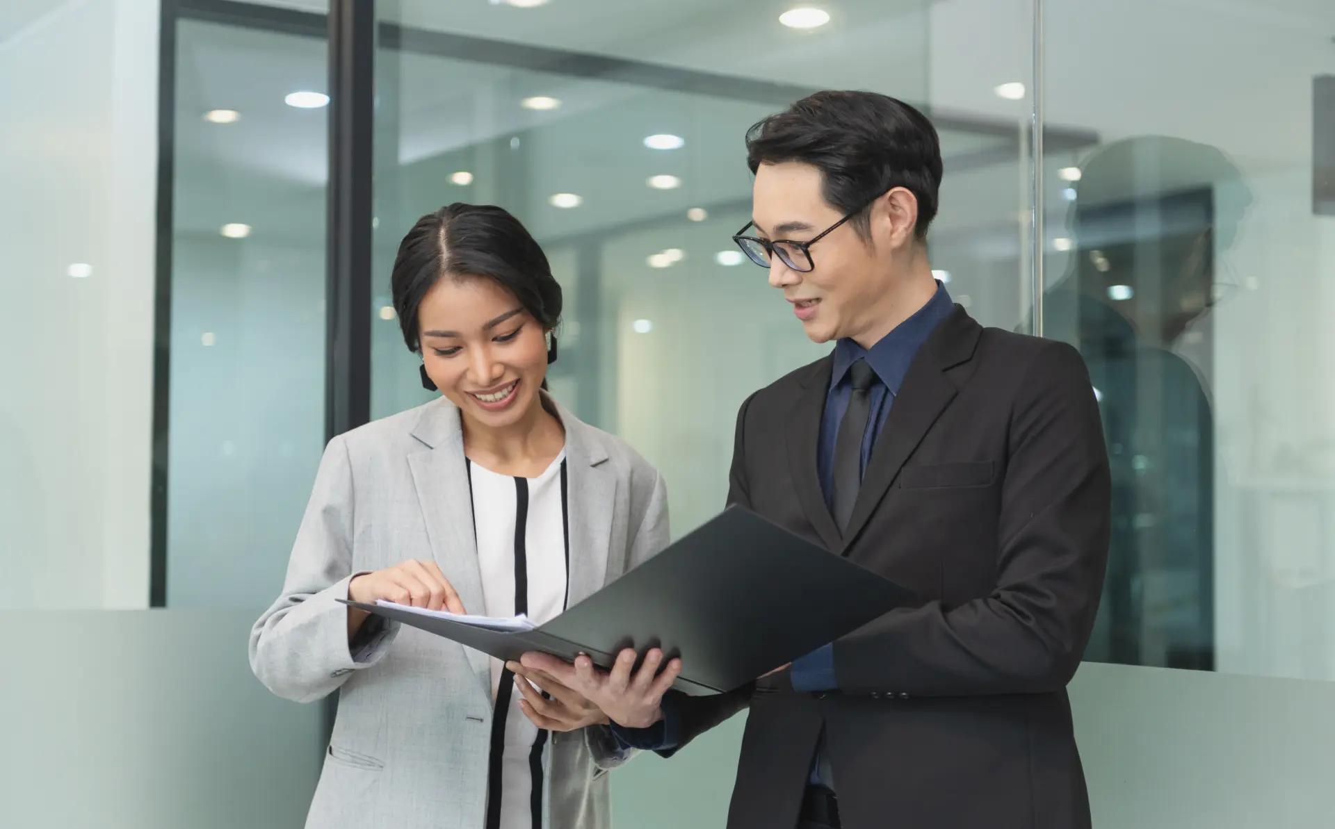 Smiling asian businesswoman showing document report her manager meeting office